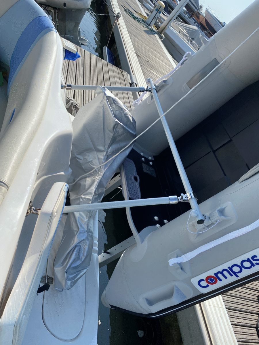 Beiboot befestigt an Motorboot. Dinghy at the stern of a small powerboat.